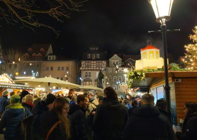 scene of the Jena Christmas market with the Hanfried statue holding Bing's floral wreath